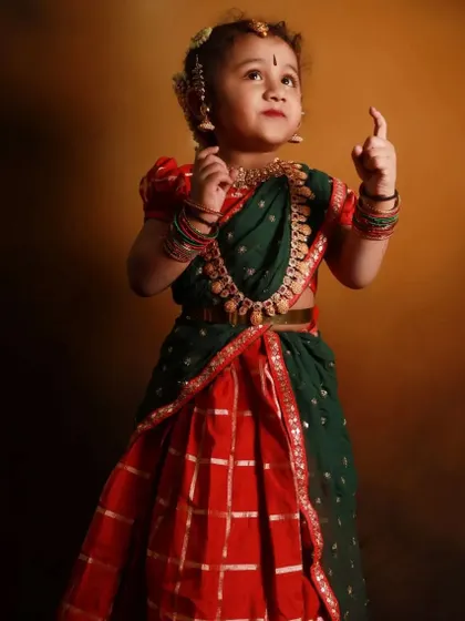 Another adorable shot of the custom-designed kids' half-saree. The combination of red and green with the temple jewelry is a classic South Indian look.