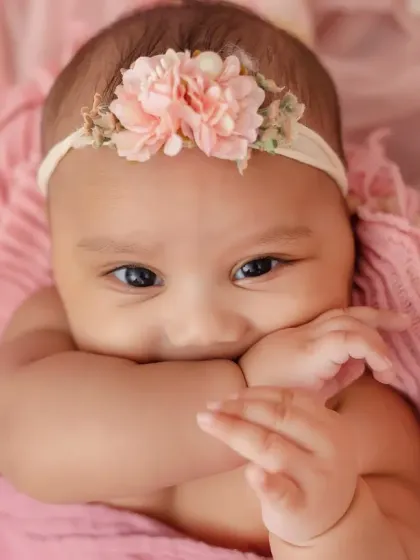 A shy but sweet close-up of this adorable chubby baby girl during her four-month milestone session.