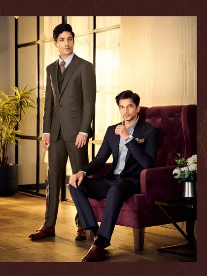 We create stunning Italian silhouettes from the finest fabrics available. This image showcases two of our classic suits, one in dark brown and one in navy blue, both exuding timeless elegance.