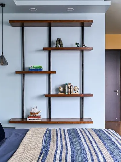 A modern boy's bedroom with a custom cane headboard, striped bedding, and a sleek, industrial-style wall shelf.