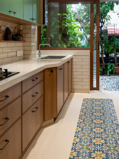 This view shows how the kitchen opens up to an outdoor space, blurring the lines between inside and out. The large window brings in abundant natural light and a sense of tranquility from the garden.