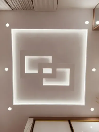 A modern, multi-layered square false ceiling design with integrated cove lighting.