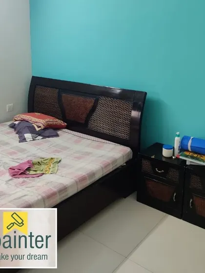 A bedroom with a bright teal accent wall, creating a fresh and vibrant atmosphere.