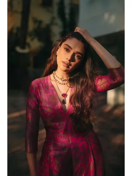 A close-up portrait in the Payal Khandwala jumpsuit, highlighting the rich color and the stunning Amrapali necklace.