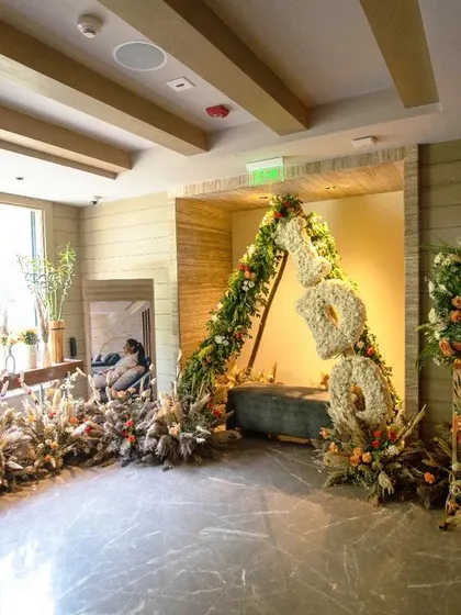 The full entrance setup, with the personalized welcome sign, a rustic floral arch, and a pathway lined with flowers, creating a warm and inviting atmosphere.