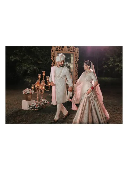 A romantic walking shot of the couple in the palace gardens at night.
