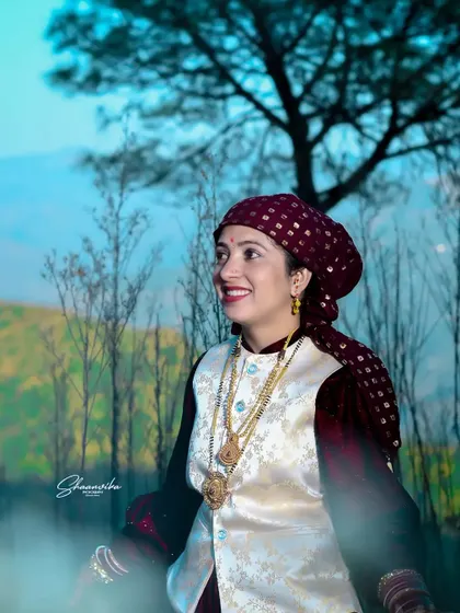 A bride wearing a traditional 'dhatu' headscarf, smiling joyfully. This portrait celebrates the rich culture and traditions of a Himachali wedding.