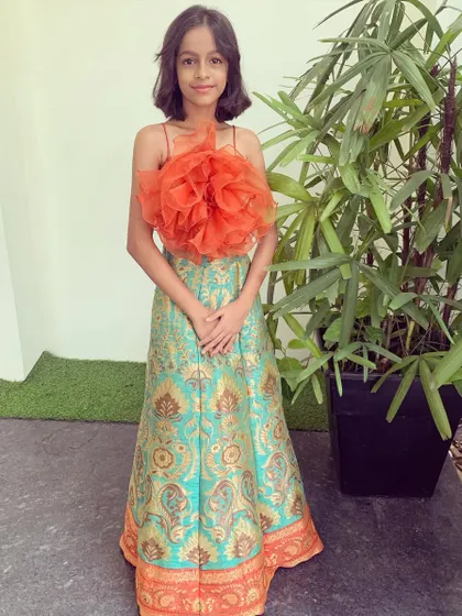 A full-length view of this adorable and unique kid's outfit. The combination of a traditional brocade skirt and a contemporary top makes it perfect for any festive occasion.