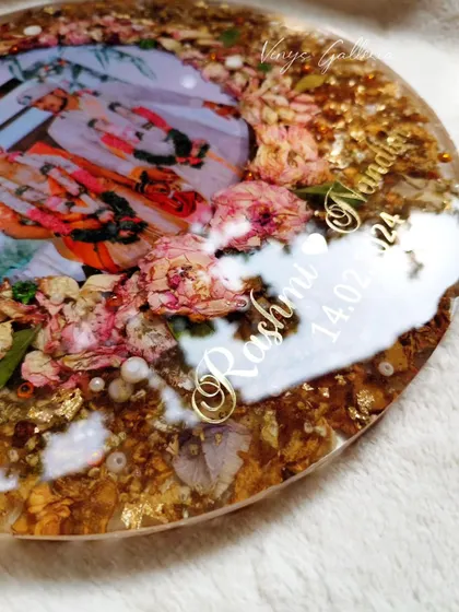 A close-up of a 12-inch round frame with full floral coverage. The addition of bright pink roses helped enhance the older, yellowish flowers.