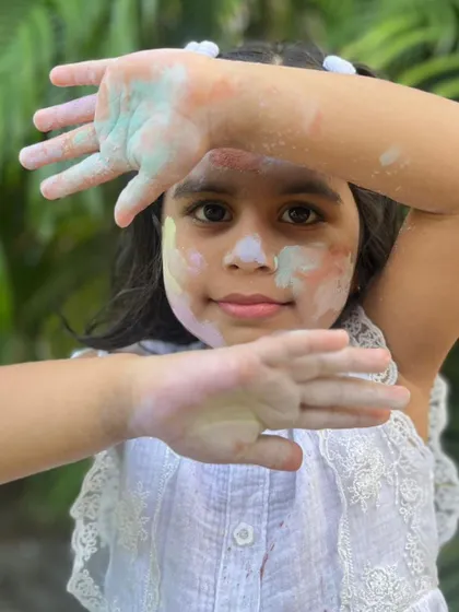 Framing a happy face with hands full of my gentle, non-toxic Holi colors.