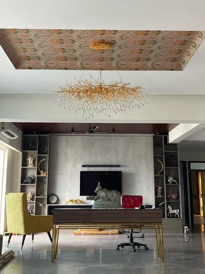 The stunning 'after' of the Lotus 300 living room. The space is now a sophisticated study and lounge, featuring a grand desk, a magnificent chandelier, and a fully-stocked, custom-built display unit.