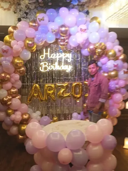 The same beautiful circular backdrop for Arzo's birthday, showing the full setup with the name in gold foil balloons against a silver shimmer curtain.