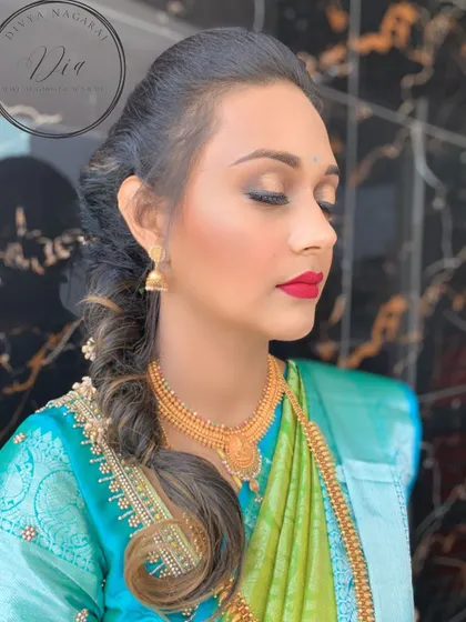 A side view highlighting the flawless makeup application and the elegant braided hairstyle. The red lip is the star of this look, providing a pop of colour that is both traditional and chic.