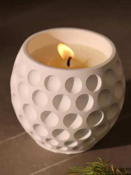 Our white scented candle with a modern golf ball texture. It’s a perfect example of our minimal design philosophy, where simple forms create a powerful impact.