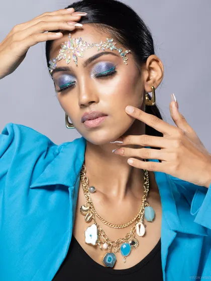 A shot focusing on the interplay between the crystal headpiece, the necklace, and the model's pose.