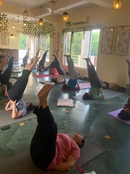 Students practicing Viparita Karani, or legs-up-the-wall pose, a gentle inversion to calm the nervous system.
