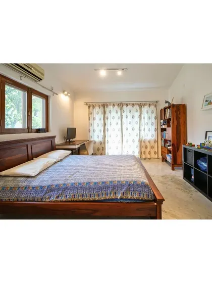 Escape to tranquility in this bedroom that embraces the rustic elegance of natural wood accents, from the bed frame to the window casings, creating a cozy retreat.