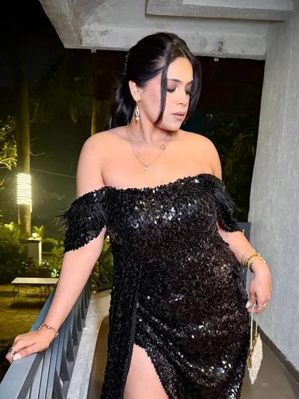 A full glam party look with a black sequin off-shoulder dress and smokey eye makeup.