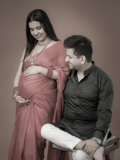 A gentle and loving pose from a traditional maternity session. The couple's soft smiles and close embrace create a feeling of warmth and intimacy.