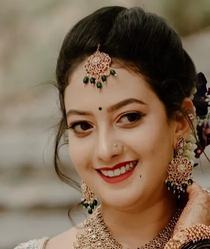 A smiling close-up portrait of a South Indian bride, highlighting her intricate jewelry, bindi, and joyful expression. We focus on capturing the beauty and happiness of the bride.