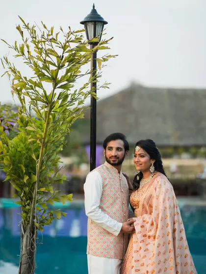 A relaxed and happy portrait of the couple by the pool at their Sangeet or Mehendi event.