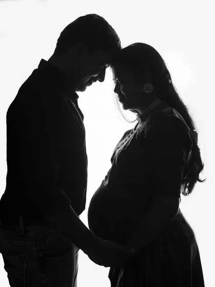 A classic black and white silhouette of a couple. This timeless and romantic pose beautifully captures the intimacy and anticipation of waiting for their baby.