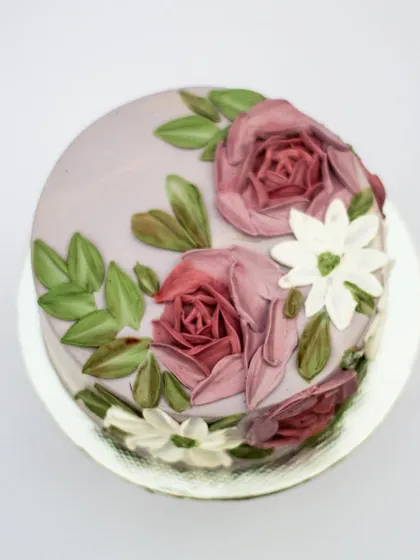 This painted cake was for a fellow baker's birthday. It features beautiful roses in dusty mauve and white daisies, a color combination I really enjoy working with. It's always special to create something for someone who shares the same passion.