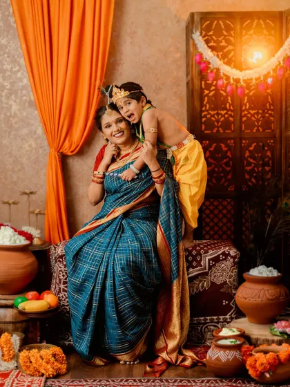 A playful and loving portrait of a mother and her son in his Krishna costume.