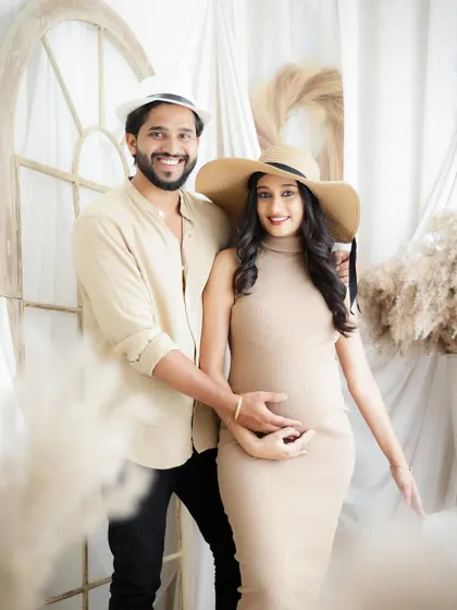 A duplicate of 38, this couple's portrait has a fun, summery vibe with matching hats and neutral-toned outfits in a boho studio setup.