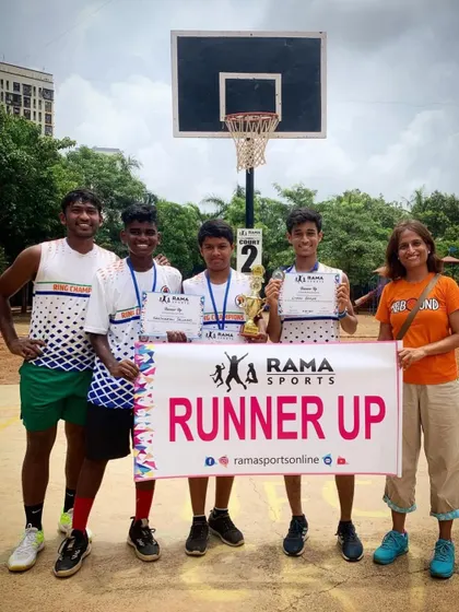 A coach stands with the runner-up team, celebrating their achievement in the tournament.