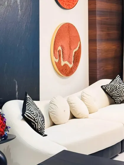 A close-up of the living room's decor, showing how I mix patterns and textures, like the zebra-print cushions, with bold wall art to add personality to a neutral space.