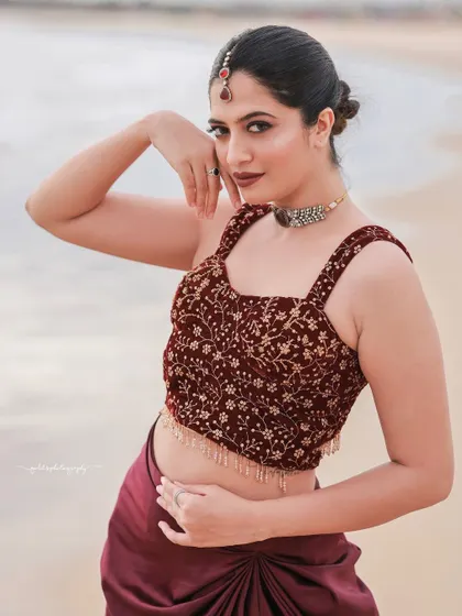 A beachside fashion shoot for a designer's modern-ethnic collection. The models are posed against the sea and coastal rocks to create a windswept, editorial feel that highlights the clothing.