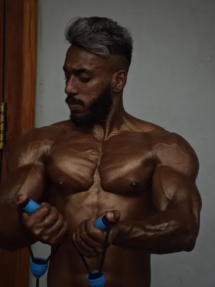 A shot of a client pumping up backstage. The chest striations and vascularity are signs that he is ready for the stage.