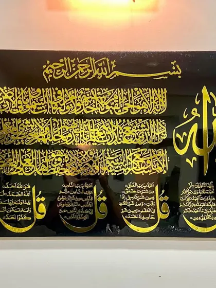 Another view of the large black and gold artwork combining Ayat al-Kursi and the Four Quls, showing its impressive scale.