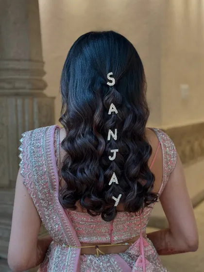 A truly personalized hairstyle! For this bride, I added crystal letter clips spelling out her partner's name down the length of her soft waves.