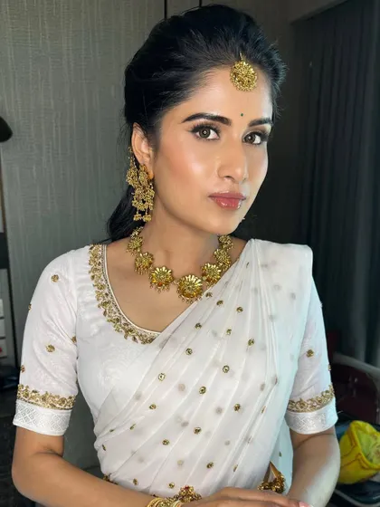 A gorgeous Haldi look in a simple white and gold saree. The makeup is fresh and radiant, perfect for the ceremony.