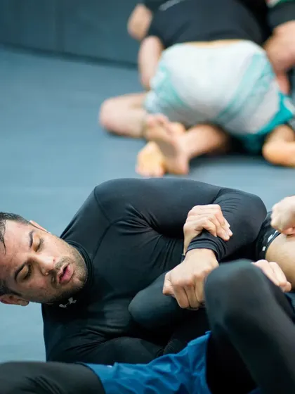 A close-up of a submission attempt during a grappling roll. This shows the intricate hand-fighting and control needed to finish a fight on the ground.