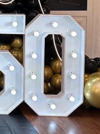 A close-up of a large, light-up marquee number '50'. These numbers make a bold statement and are perfect for celebrating milestone birthdays.
