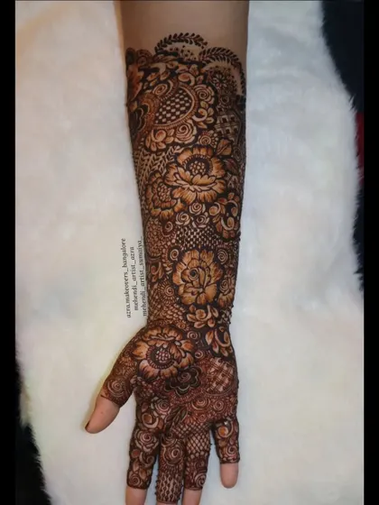 A full arm view of a floral bridal mehendi, showcasing the beautiful flow of the design from hand to elbow.