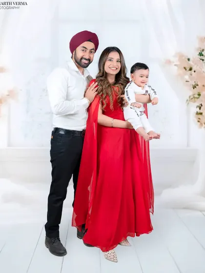 An elegant family portrait with the mother in a stunning red dress. The family stands together, creating a sophisticated and loving image.