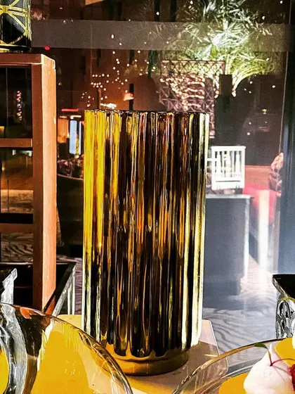 A close-up of a textured golden vase, reflecting the festive lights of a Diwali event. Such decorative elements enhance the feeling of luxury and celebration.