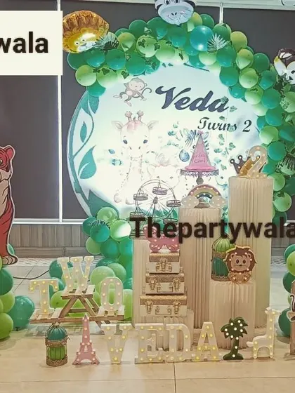 A detailed jungle theme for a second birthday, with lots of animal cutouts and a picket fence.