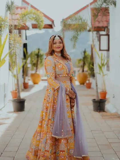 Radiating beauty at the wedding. This is the groom's bhabhi, looking stunning in a unique yellow and purple lehenga.
