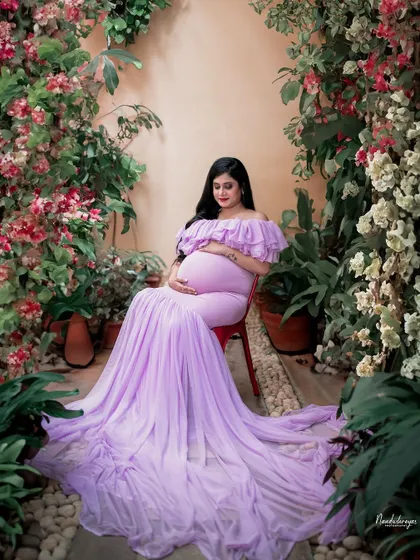 Seated like a queen on her throne, this mother-to-be is surrounded by a cascade of flowers. A truly regal garden maternity portrait.