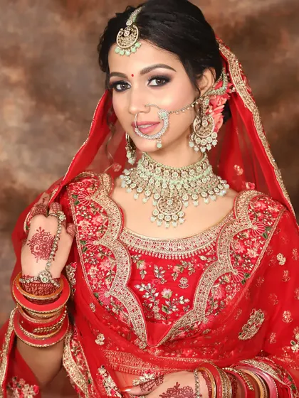 A beautiful portrait of a bride in red. Her makeup is classic and clean, with a sharp winged liner and a flawless base that lets her natural beauty shine through.