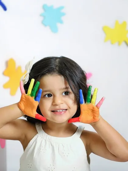 A close-up of our little Picasso. Her happy expression and colorful hands perfectly capture the fun and creativity of this art-themed session.