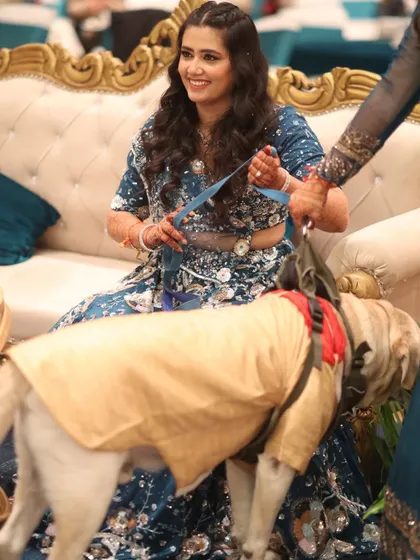 We believe in including all family members, even the furry ones! This heartwarming shot captures the bride with her pet dog, who was also dressed for the occasion.