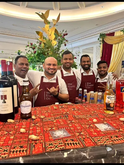 Our team in branded red aprons at an event with a traditional Indian theme. We blend seamlessly into the decor while providing top-tier service.