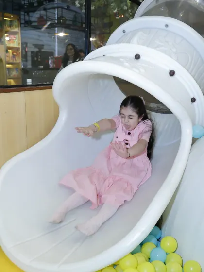 Whee. A guest enjoys the rush of our enclosed spiral slide, which ends in a soft landing in the ball pit. Our play structures are designed for maximum fun and safety.