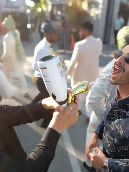 Taking the party to the streets. Our founder uses a shot gun to serve drinks during a wedding 'baraat', showing how we can adapt our service to any part of the celebration.